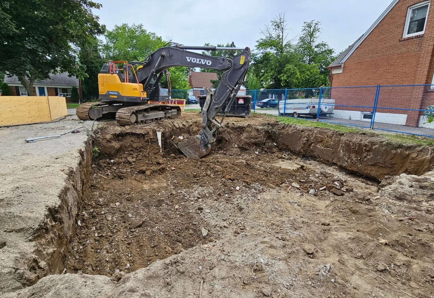 Excavator working an open cellar hole where a building has been taken down
